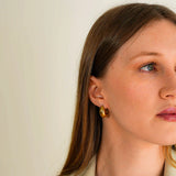 A woman wearing the Amaya Earrings while looking right