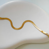 The 18K gold plated Kaia Bracelet on a white plate