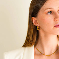 A woman wearing the Leona 18k gold plated earrings 