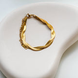 The 18k gold plated Selene bracelet on a white plate