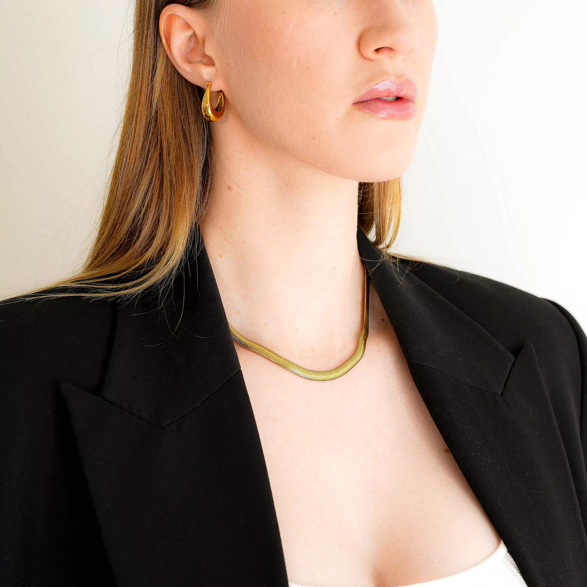 A woman wearing 18K gold plated Seraphine necklace looking right